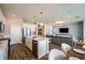 Open concept kitchen and living room area with hardwood floors and modern finishes at 9997 Surrey Rose Dr, San Antonio, FL 33576