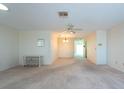 Spacious living room with carpet, ceiling fan, and neutral paint ready for personalization at 106 Silverbell Ct, Sun City Center, FL 33573
