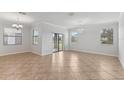 Bright, open-concept living area featuring tile flooring, large windows, and sliding glass doors to the outdoors at 1119 Ballard Green Pl, Brandon, FL 33511