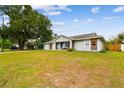 Charming single-story home with a well-manicured lawn, mature trees, and an attached garage at 12106 Meadow Ln, San Antonio, FL 33576