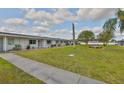 Beautifully landscaped exterior showcasing a well-manicured lawn and sidewalk in a tranquil neighborhood at 1304 Burbank Ct, Sun City Center, FL 33573