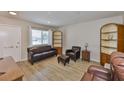 Cozy living room with beautiful floors, ample natural light, comfortable leather seating and wooden shelves at 1304 Burbank Ct, Sun City Center, FL 33573