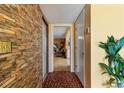 Hallway with a unique brick wall and mosaic tiled floor leading to the living room at 1453 62Nd S Ter, St Petersburg, FL 33705