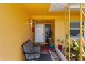 Inviting front porch with a cozy seating area and decorative plants in a sunny location at 1453 62Nd S Ter, St Petersburg, FL 33705