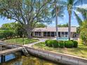 Scenic backyard view featuring a wooden dock and refreshing swimming pool at 150 Carlyle Dr, Palm Harbor, FL 34683