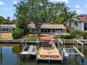 Waterfront home featuring a private dock with boat lifts and a refreshing pool at 150 Carlyle Dr, Palm Harbor, FL 34683