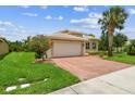 Charming single-story home boasting an attached garage, brick-paved driveway, and blossoming landscaping at 16101 Cape Coral Dr, Wimauma, FL 33598