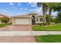 Inviting single Gathering home featuring a brick driveway, attached garage, and beautifully landscaped front yard at 16101 Cape Coral Dr, Wimauma, FL 33598