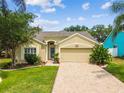 Charming single-story home with a brick driveway, two-car garage, well-kept lawn and landscaping at 1758 Biarritz Cir, Tarpon Springs, FL 34689