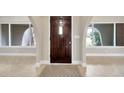 Inviting foyer with beautiful tile flooring, arched windows and a solid front door at 1890 Wateroak W Dr, Clearwater, FL 33764