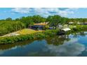 Back view of property overlooking waterfront, screen lanai, dock, and lush landscape at 1890 Wateroak W Dr, Clearwater, FL 33764