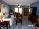 Comfortable living room with hardwood floors, a ceiling fan, and ample natural light at 2025 Dover Ct, Oldsmar, FL 34677
