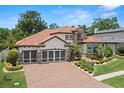 Beautiful home featuring a terracotta roof, three-car garage, and a manicured lawn at 2142 Scarlet Oaks St, Clearwater, FL 33759