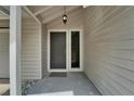 Welcoming front door with sidelight, exterior lantern, and neutral siding at 23739 Forest View Dr, Land O Lakes, FL 34639