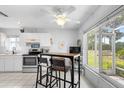 Bright kitchen with white cabinets, stainless steel appliances, and a cozy dining area with views of the outdoors at 2413 Oxford Down Ct # 58, Sun City Center, FL 33573