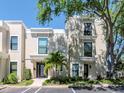 Modern townhome exterior showcasing large windows, a well-manicured lawn, palm tree, and on-site parking at 2807 W Hawthorne Rd # 11, Tampa, FL 33611