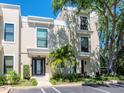 Modern townhome exterior showcasing a well-manicured lawn, palm tree, on-site parking, and large windows at 2807 W Hawthorne Rd # 11, Tampa, FL 33611
