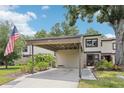 Charming townhome featuring a covered parking, landscaped yard and American flag at 330 Woods Landing Trail, Oldsmar, FL 34677