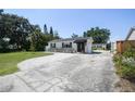 Inviting exterior view of home with a long driveway and lush landscaping under a clear sky at 3315 W Pearl Ave, Tampa, FL 33611