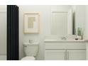 Well-lit bathroom features a sleek vanity, toilet, and a shower with a dark shower curtain at 3469 Lapis Lake Dr, Zephyrhills, FL 33541