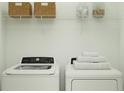 Bright laundry room with modern washer and dryer, complemented by stylish shelving at 3469 Lapis Lake Dr, Zephyrhills, FL 33541