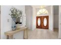 Bright foyer with wood-look tile floors, stylish console table, and decorative double doors at 3908 Lithia Ridge Blvd, Valrico, FL 33596