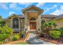 Inviting front entrance with decorative double doors, lovely landscaping, and a brick-lined walkway at 3908 Lithia Ridge Blvd, Valrico, FL 33596
