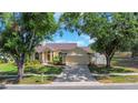 Well-maintained home featuring lush trees, a long driveway, and a two-car garage at 3908 Lithia Ridge Blvd, Valrico, FL 33596