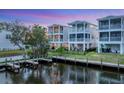 Beautiful backyard featuring multiple homes with balconies, canal access with boat docks, and green landscaping at 4357 Marina View Way, Cortez, FL 34215