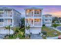 Charming two-story home with dual balconies, lush landscaping, and a paved driveway leading to the garage at 4357 Marina View Way, Cortez, FL 34215