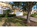 Charming yellow home with a brick driveway, well-kept lawn, mature landscaping, and a tree at 4605 Casswell Dr, New Port Richey, FL 34652