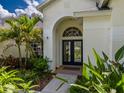 Welcoming front entrance with elegant double doors, arched window, and mature landscaping at 4612 River Overlook Dr, Valrico, FL 33596
