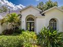 Inviting front entrance with arched windows and a well-manicured garden, adding to the home's curb appeal at 4612 River Overlook Dr, Valrico, FL 33596