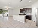 Open-concept kitchen features a large island, stainless steel appliances, and dark wood cabinetry at 5344 Sylvester Loop, Tampa, FL 33610