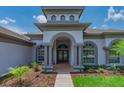 Inviting front entrance with decorative columns and well-manicured landscaping, enhancing curb appeal at 5507 Keeler Oak St, Lithia, FL 33547