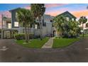 Attractive condo building with mature palms and walkway at 5712 Biscayne Ct # 103, New Port Richey, FL 34652