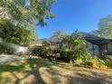 Expansive backyard featuring lush landscaping, mature trees, and a screened-in pool area at 6073 115Th N Ave, Pinellas Park, FL 33782