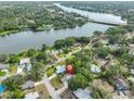 Aerial view showcasing a neighborhood home near a beautiful lake and surrounded by mature trees at 6603 Oakview Ter, Tampa, FL 33610