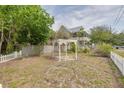 A quaint backyard with a decorative pergola and a partial view of the home at 6904 S Fitzgerald St, Tampa, FL 33616