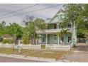 Charming two-story home featuring an inviting porch and a white picket fence at 6904 S Fitzgerald St, Tampa, FL 33616
