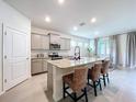 Bright kitchen with granite countertops, stainless steel appliances, and seating at the island at 8214 Wheat Stone Dr, Zephyrhills, FL 33540