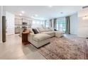 Open-concept living area featuring a large sectional couch and modern decor at 8214 Wheat Stone Dr, Zephyrhills, FL 33540