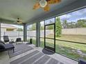 Relaxing screened porch overlooking the backyard and equipped with ceiling fans at 8214 Wheat Stone Dr, Zephyrhills, FL 33540
