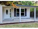 Close up of the charming covered entry featuring an updated door and fresh exterior paint at 10006 Memorial Hwy, Tampa, FL 33615