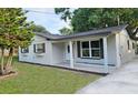 Charming home featuring a covered porch, fresh exterior paint and updated windows with decorative shutters at 10006 Memorial Hwy, Tampa, FL 33615
