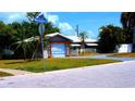 Inviting single-story home featuring a white tile roof, one-car garage, and lush landscaping in a corner lot at 101 S Maywood Ave, Clearwater, FL 33765