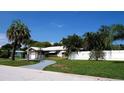 Landscaped front yard showcasing a single-story home with a white fence, offering privacy and curb appeal at 101 S Maywood Ave, Clearwater, FL 33765