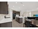 Open-concept kitchen with an island, stainless steel appliances, and dark wood cabinets at 10379 Bridgegate Heights Loop, San Antonio, FL 33576