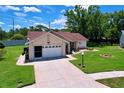 Charming single-story home showcasing an attached garage and a well-maintained lawn at 10520 Tapestry Dr, Port Richey, FL 34668