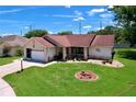 Charming single-story home with a manicured lawn and a circular garden at 10520 Tapestry Dr, Port Richey, FL 34668